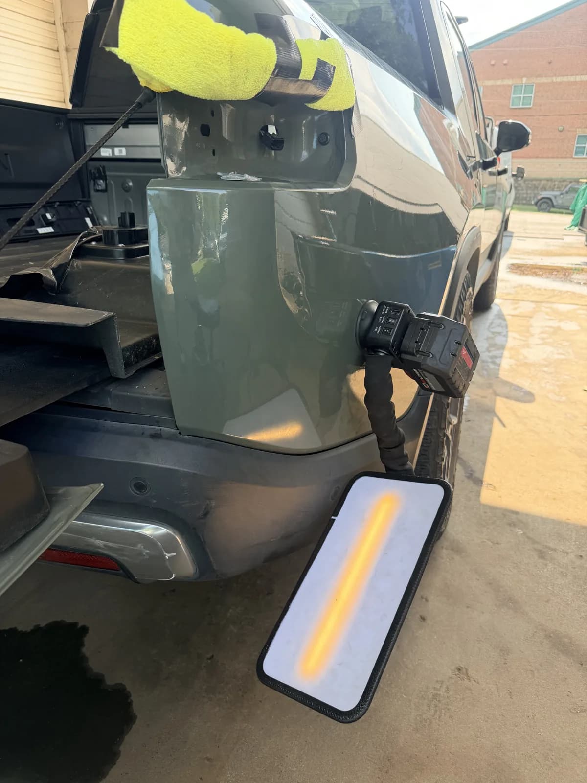 LED light board positioned against a green Rivian panel to read surface distortion.