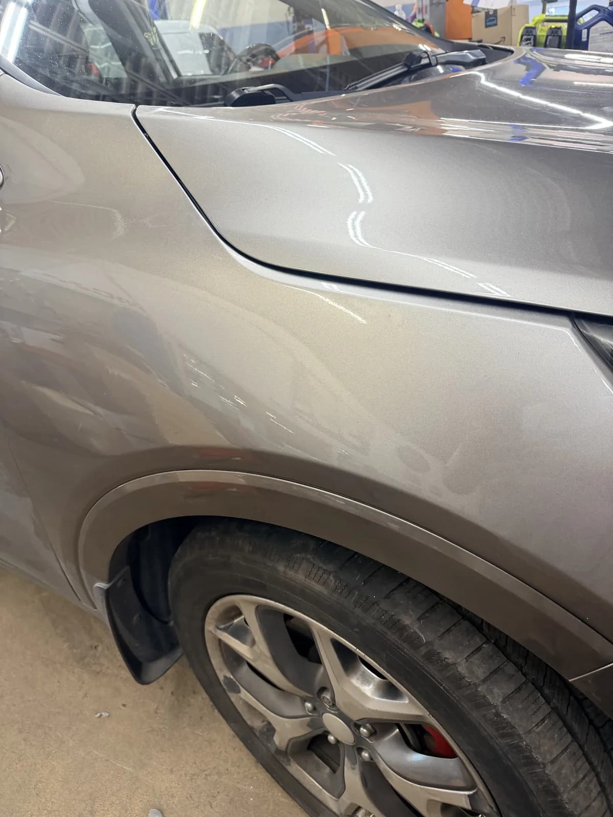 The same silver SUV fender after repair, wheel arch line restored.