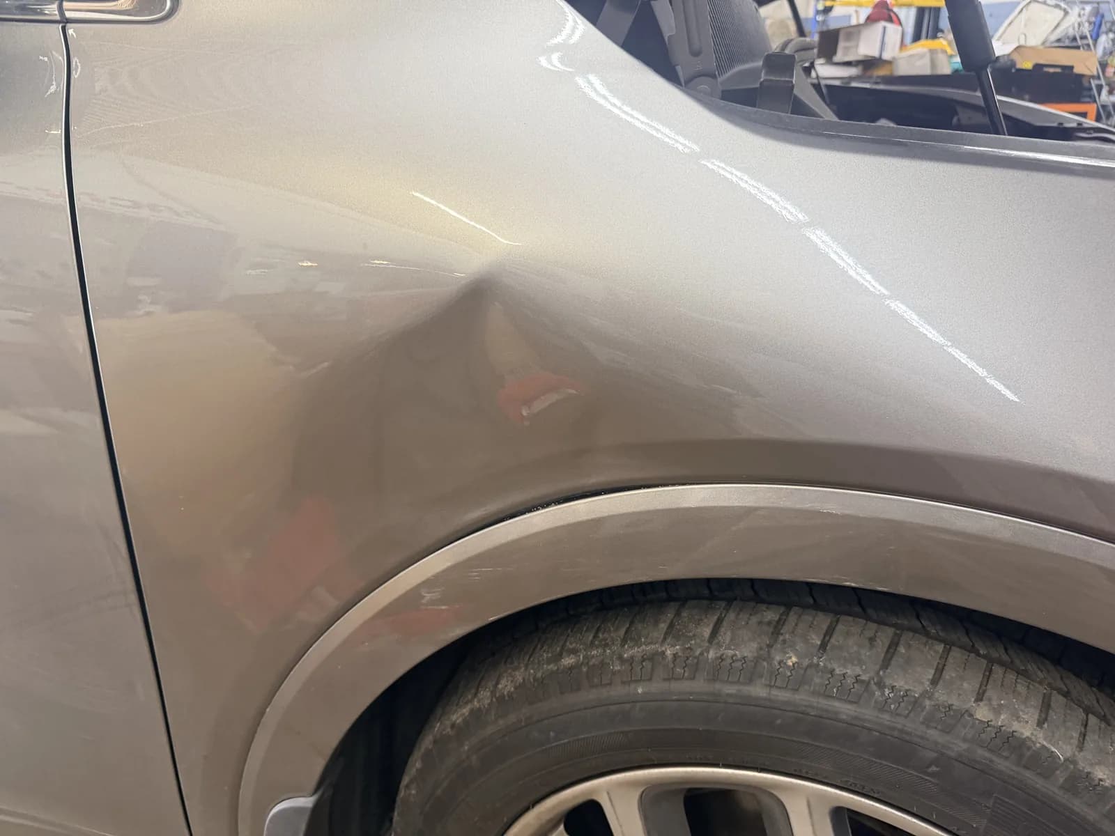 Crease above the wheel arch on the front fender of a silver SUV.