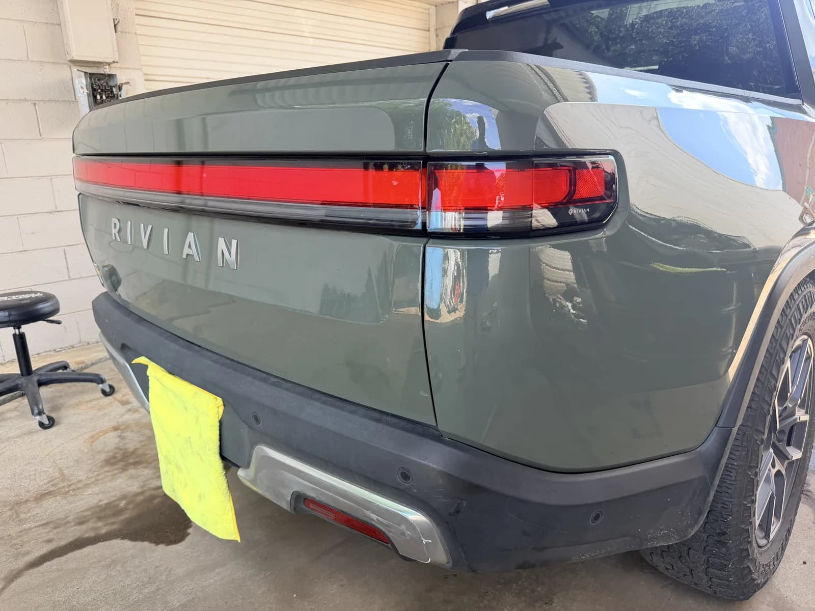 The same Rivian R1T tailgate after repair, reflecting cleanly.